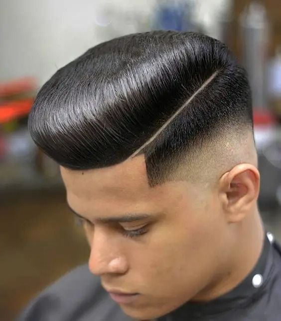 "A bold and geometric undercut hairstyle fade featuring a perfectly leveled flat top that stands tall, paired with sharp, skin-faded sides for a striking, structured look."
