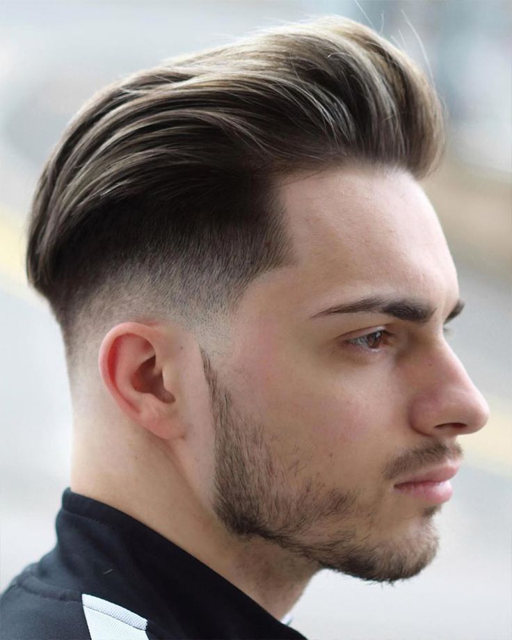 man with a long, swept back pompadour and high taper fade