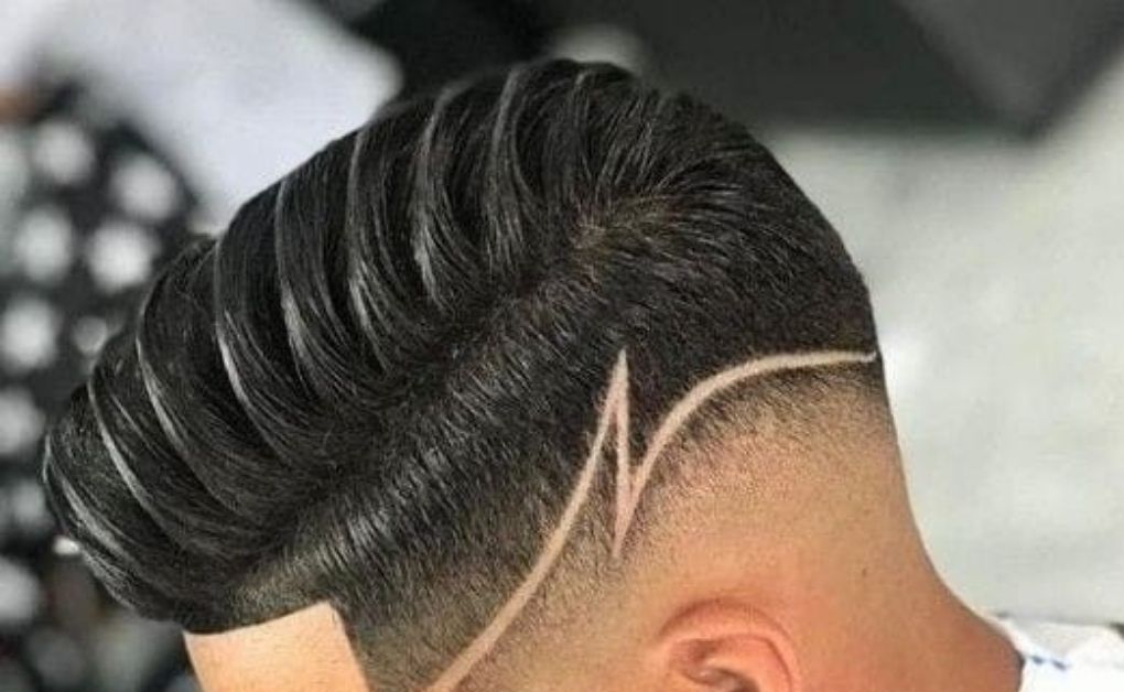 Classic men’s hard part fade haircut featuring a clean, shaved side part for a sharp and structured look.