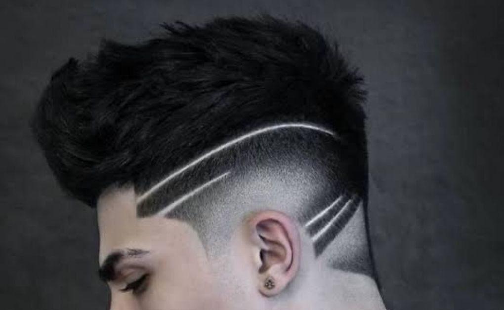 Bold mohawk fade haircut for men featuring a wide strip of hair in the center with cleanly faded sides.