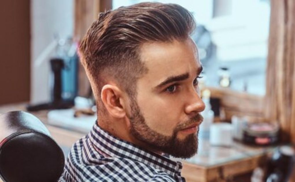 "A sophisticated Seamless Side Blend featuring long hair slicked back with a polished finish, contrasted by clean and sharp faded sides."