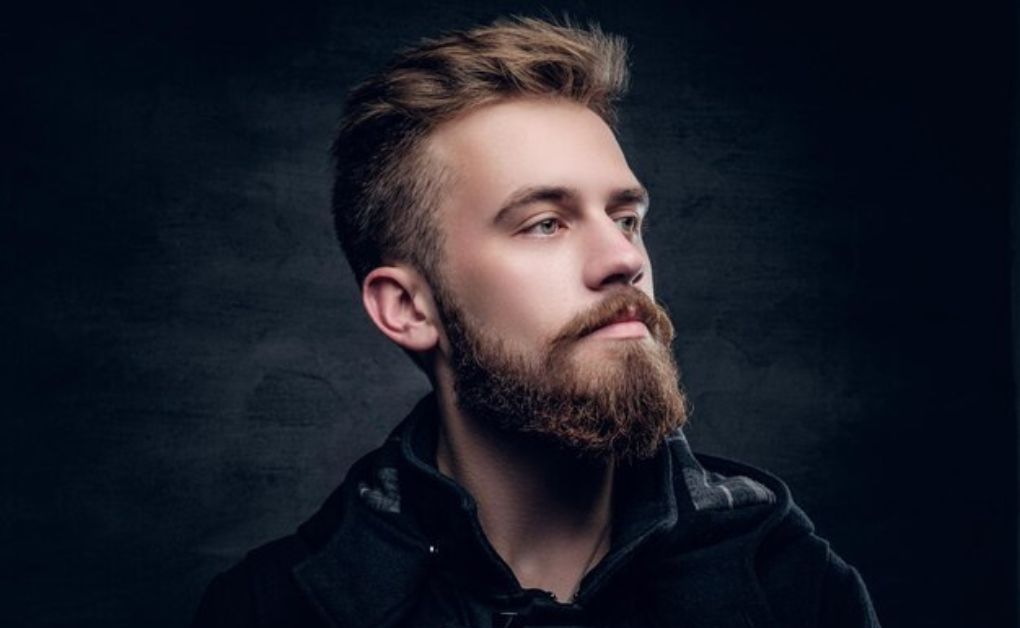Bold frohawk hairstyle for black men featuring a natural afro texture and a circular burst fade around the ears.