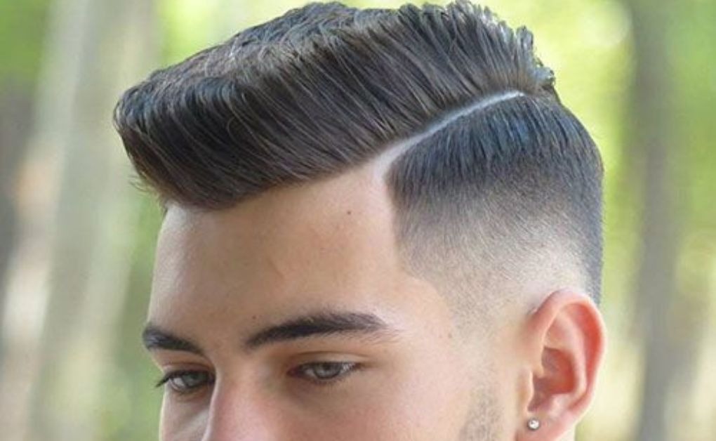 "A subtle and classy Side-shaved look  with a low fade that starts just above the ears, providing a clean edge while maintaining a fuller look on the sides."